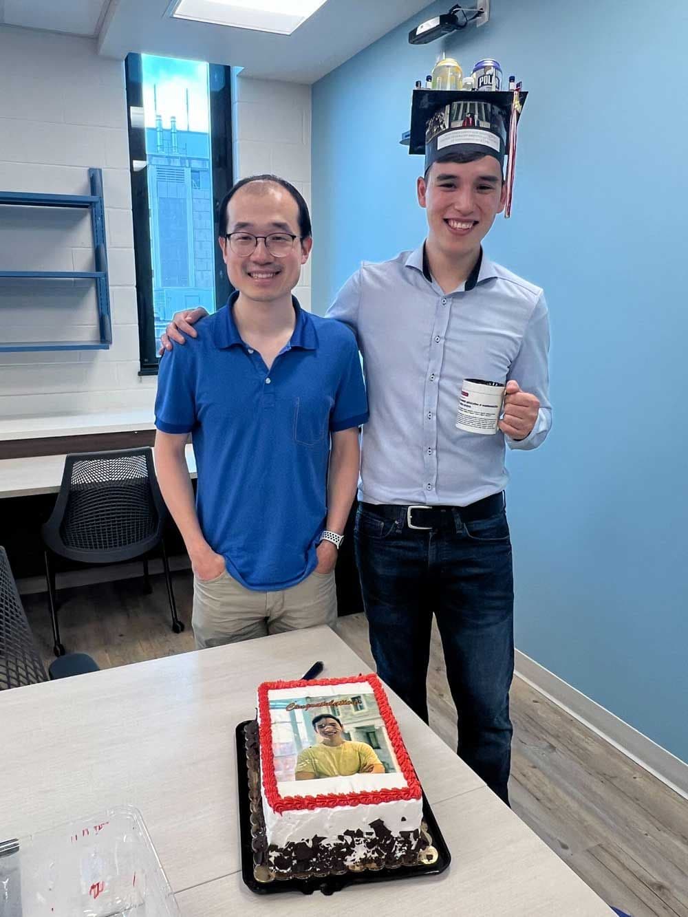 Jonas and Song standing in front of a cake